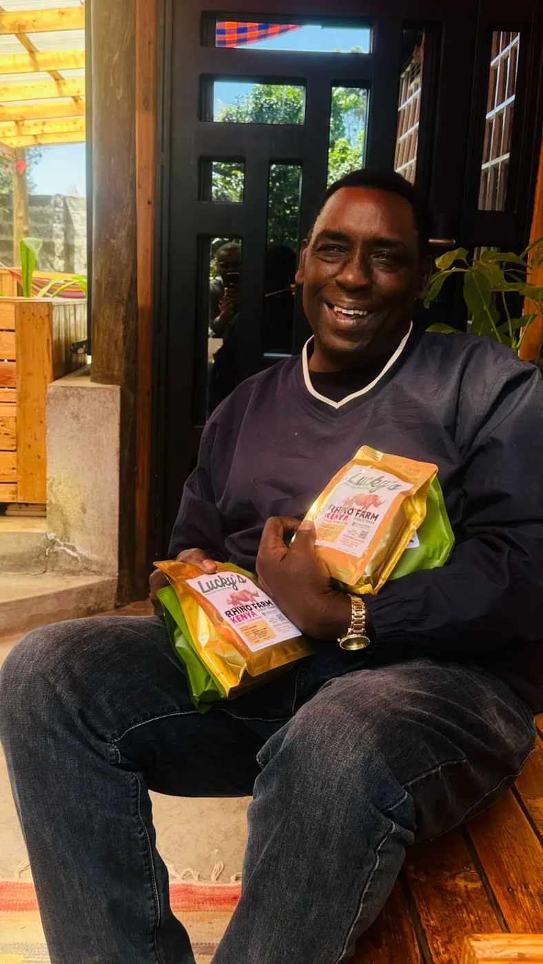 Our partner at Rhino Farm, Kenya, holding two bags of Lucky's Rhino Farm coffee